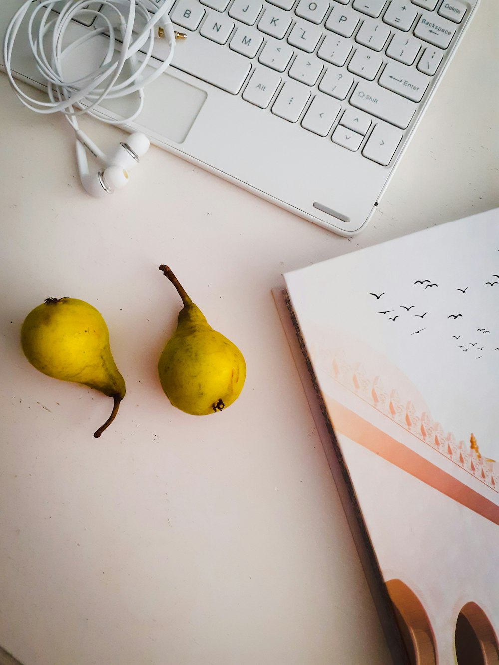 yellow round fruit beside white apple earpods