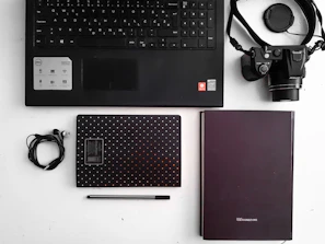 A creative flat lay of tech gadgets and notebooks used for blogging.