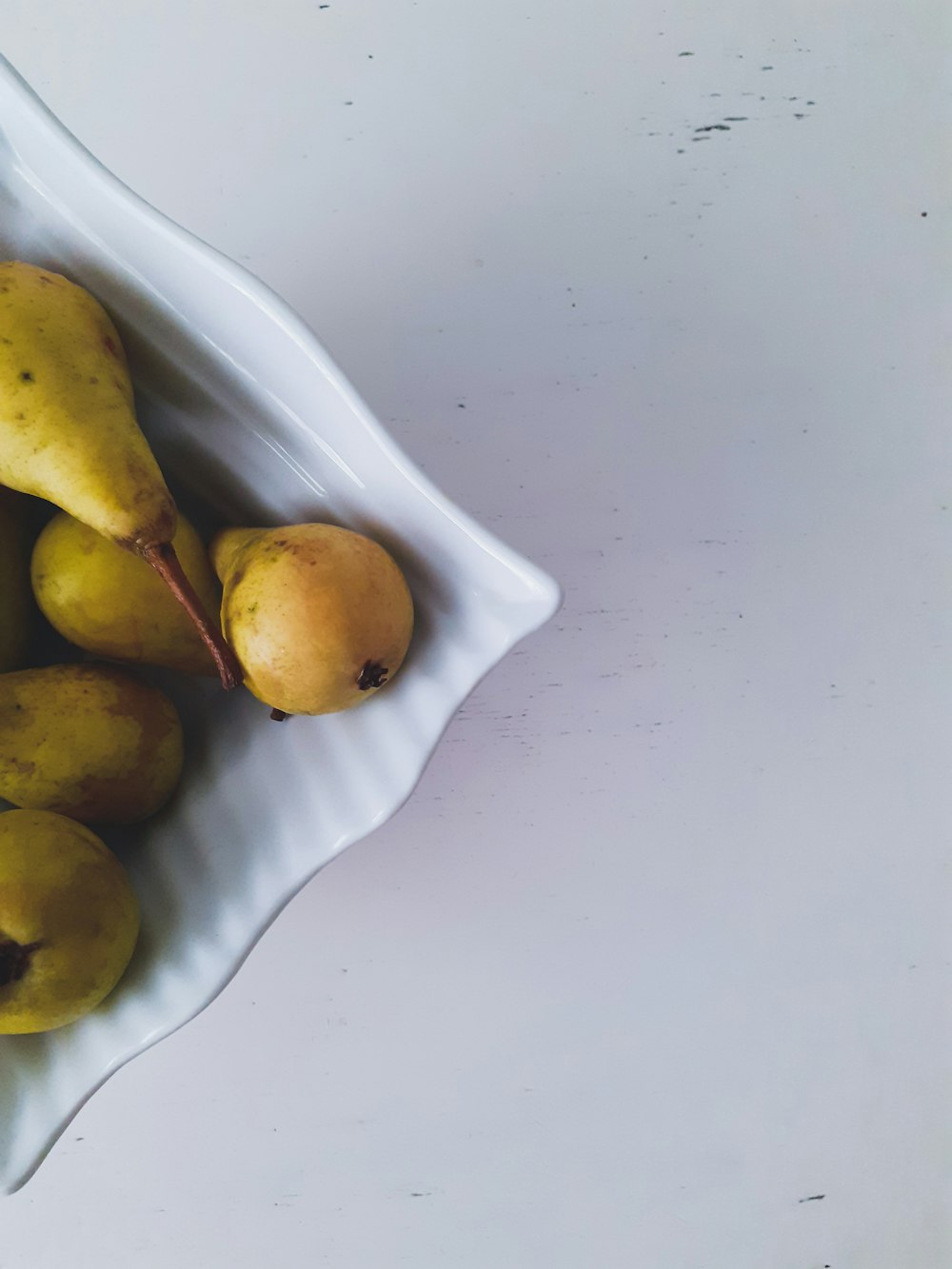 green and yellow round fruits on white ceramic plate