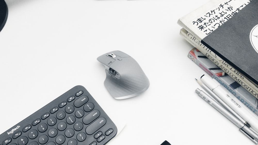 black and gray cordless computer mouse beside black computer keyboard