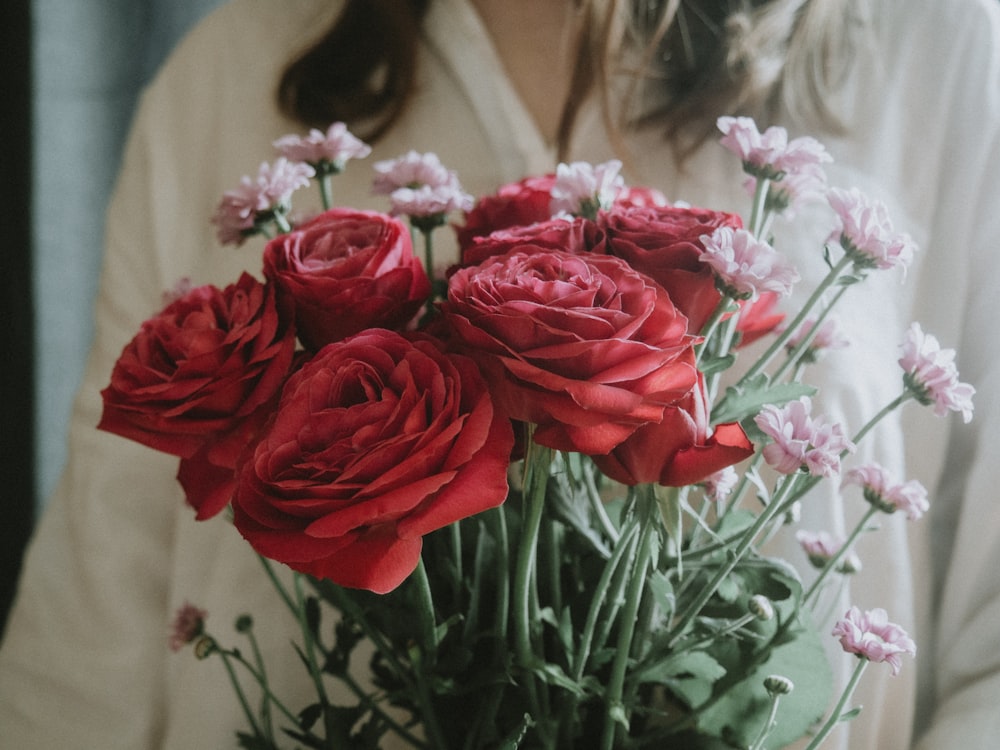 赤いバラの花束を持つ女性