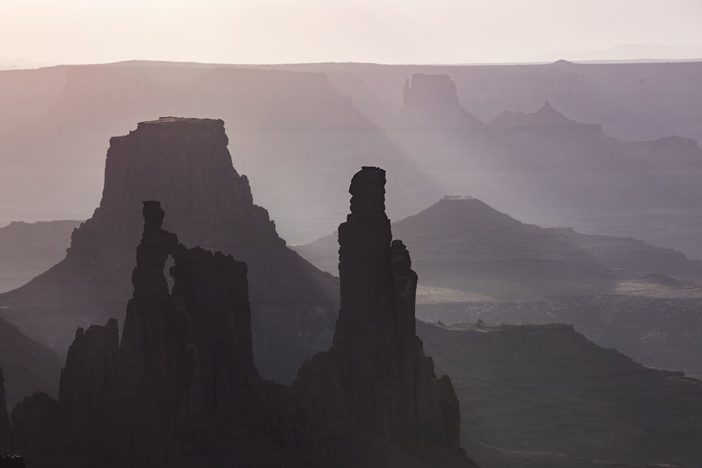 silhouette of rock formation near body of water during daytime