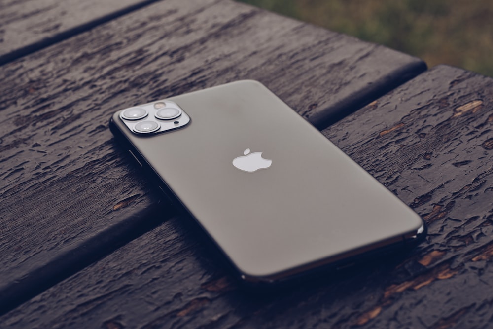 silver macbook on brown wooden table