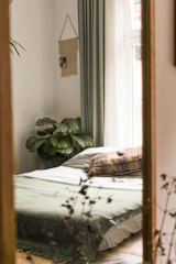 A serene bedroom with soft textiles and muted green-grey accents.