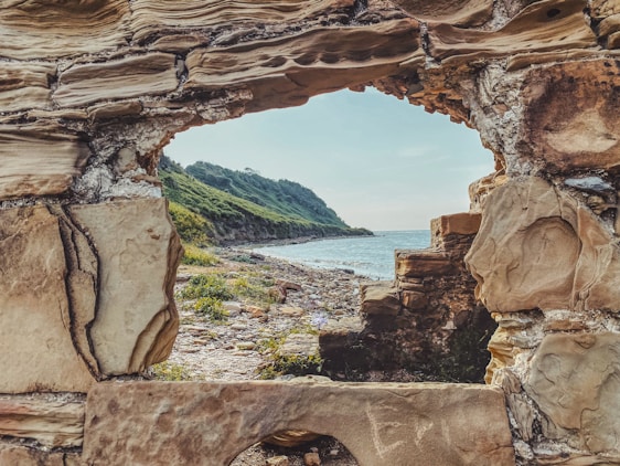brown rock formation near body of water during daytime