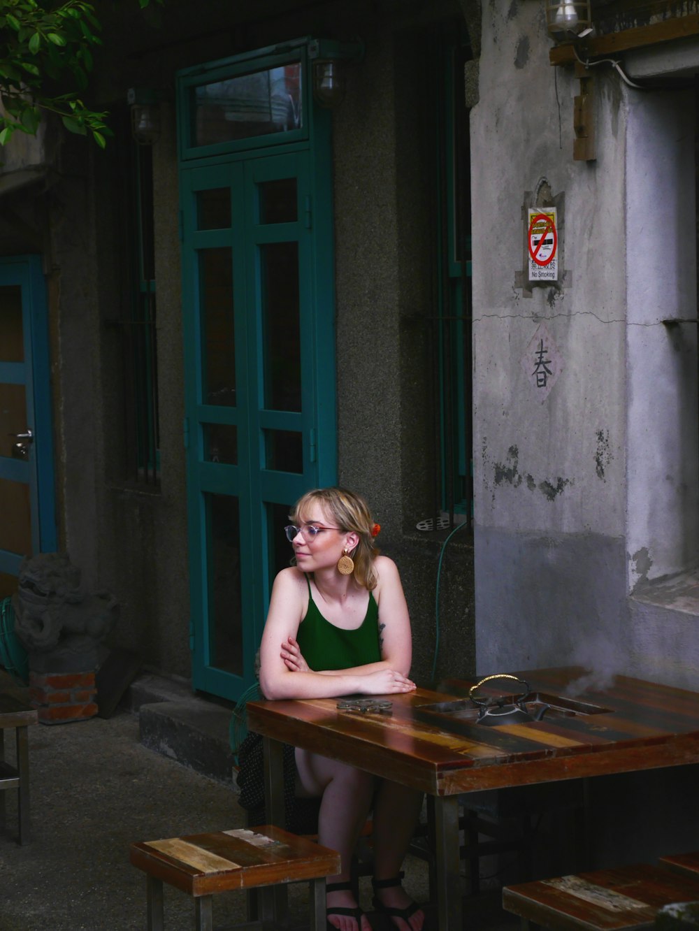 woman in black tank top sitting on brown wooden bench