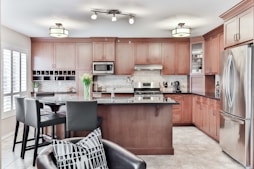 black leather padded chair beside brown wooden kitchen cabinet