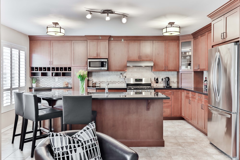 black leather padded chair beside brown wooden kitchen cabinet