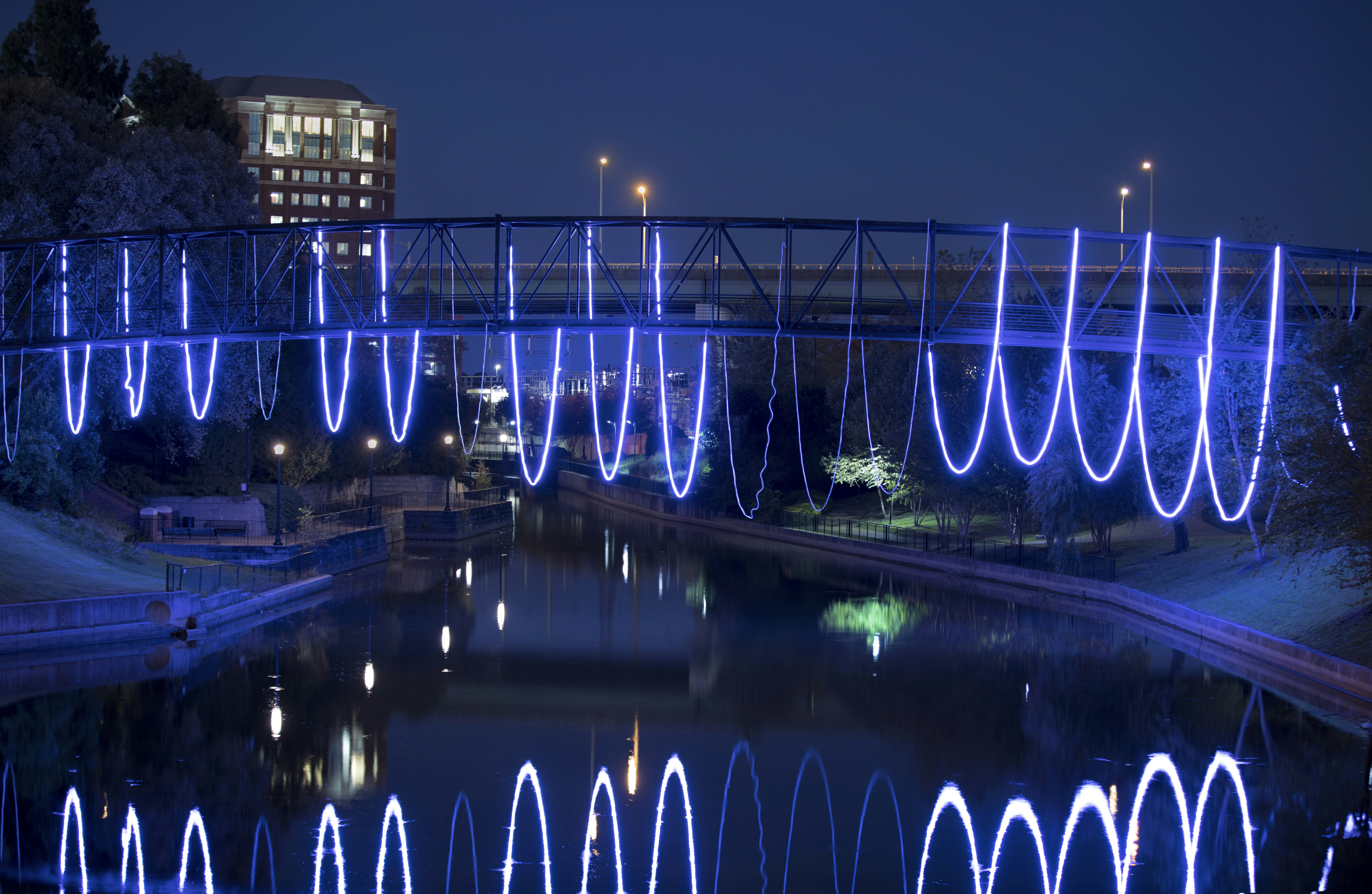 blue lighted bridge over river during night time, 