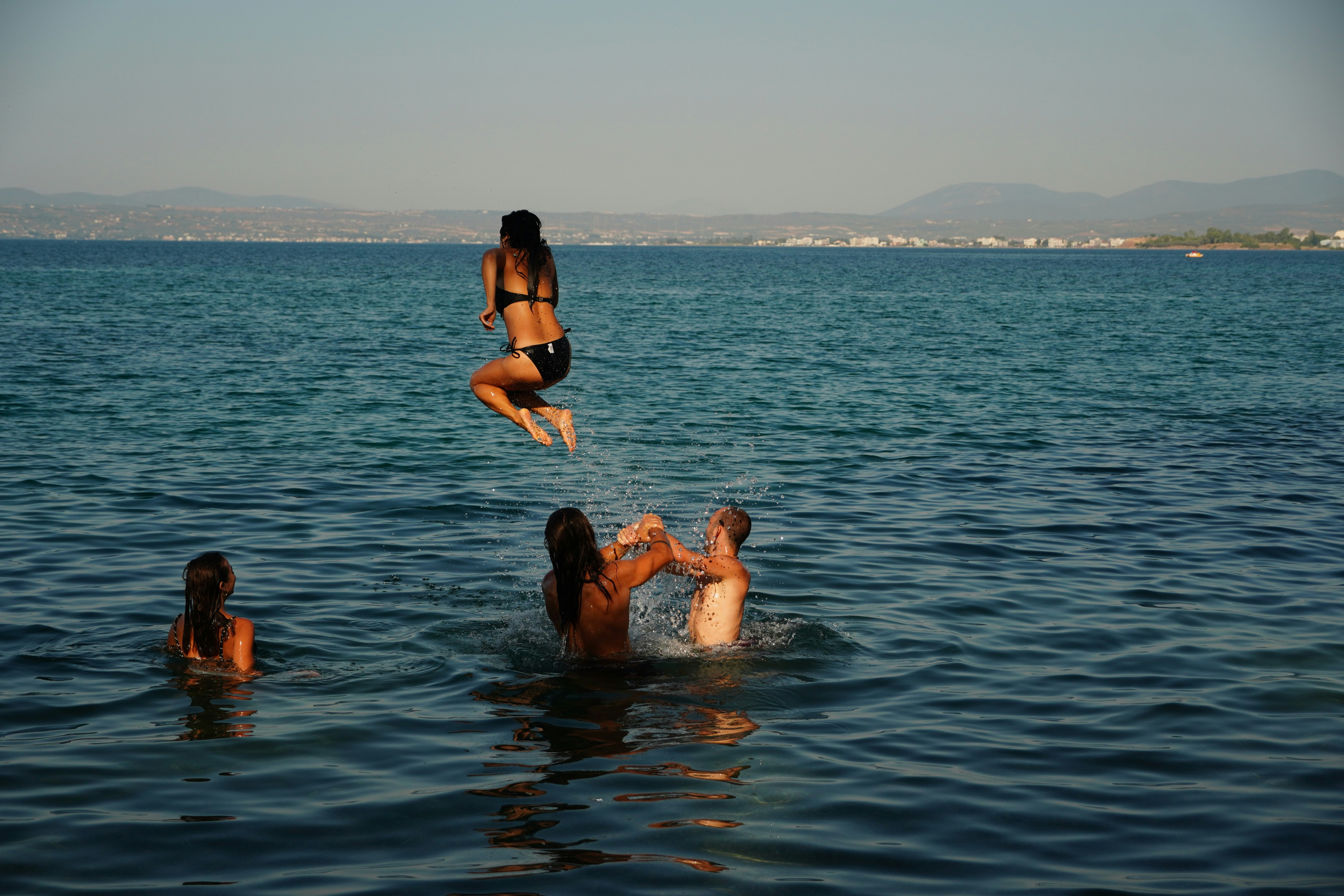 woman in black bikini top and black panty on body of water during daytime