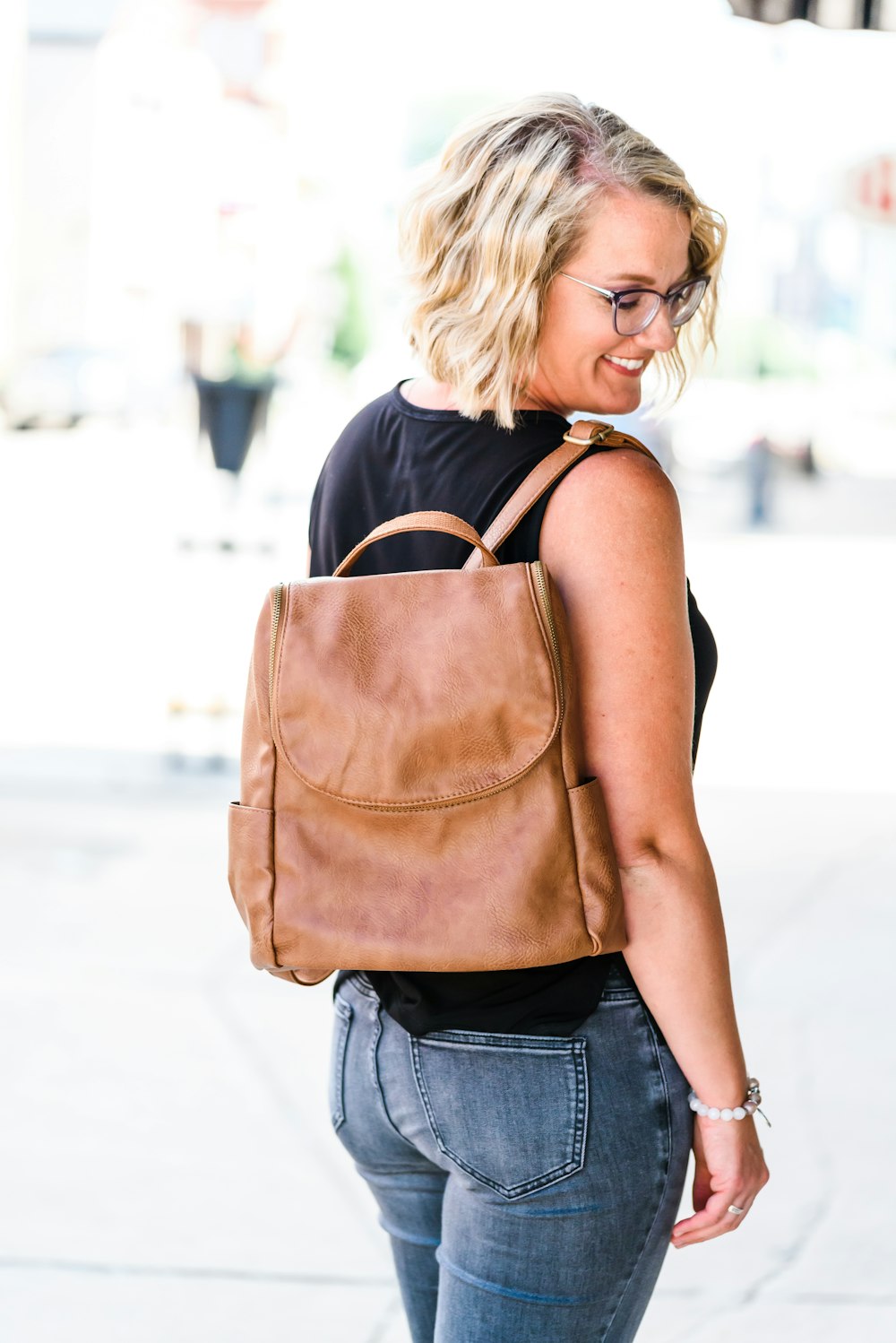 woman in brown leather sling bag