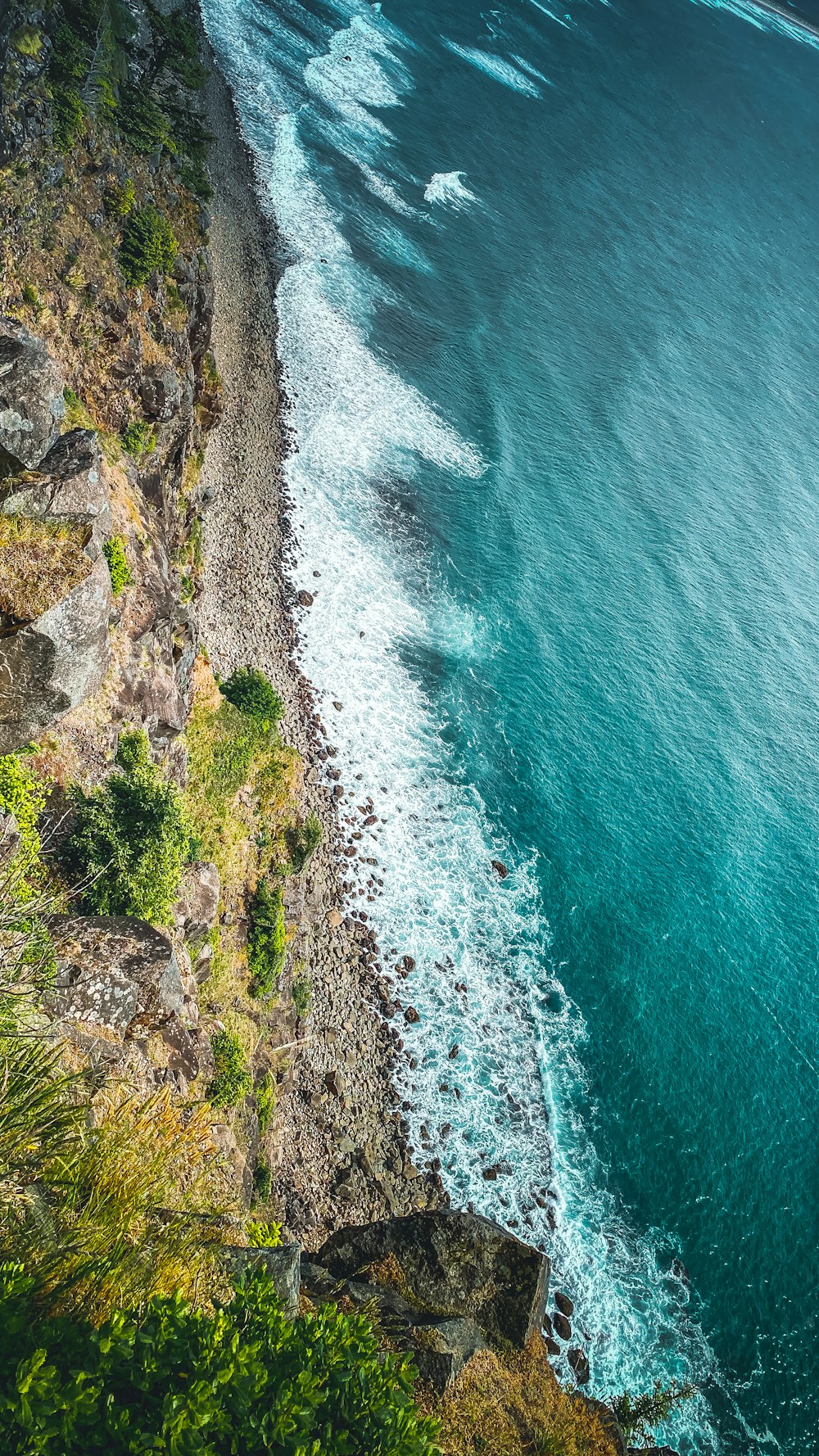 Vista aérea de las olas del océano rompiendo en la costa rocosa durante el día