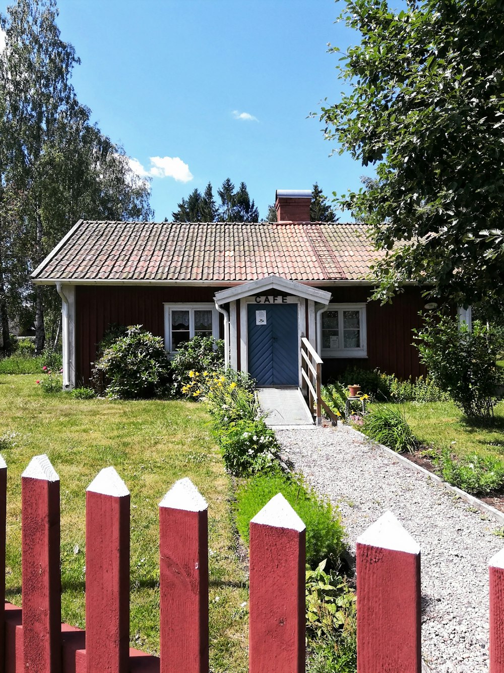 brown and white wooden house near green trees during daytime