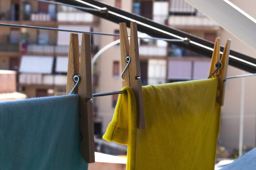 yellow textile on brown wooden clothes hanger