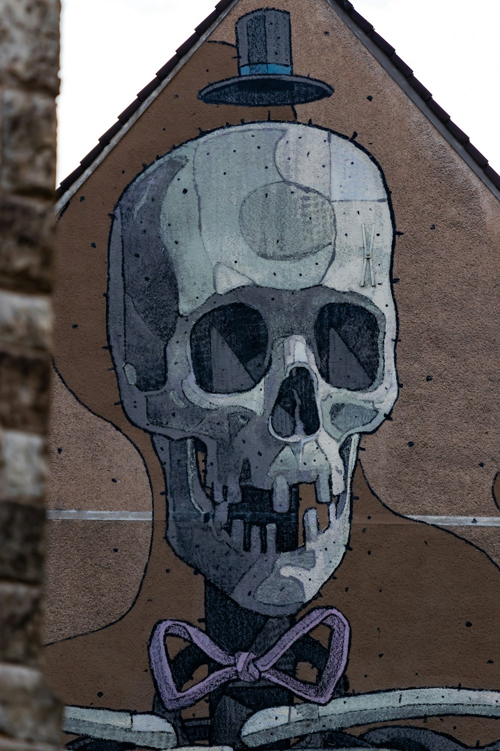 black and white skull graffiti on brown brick wall