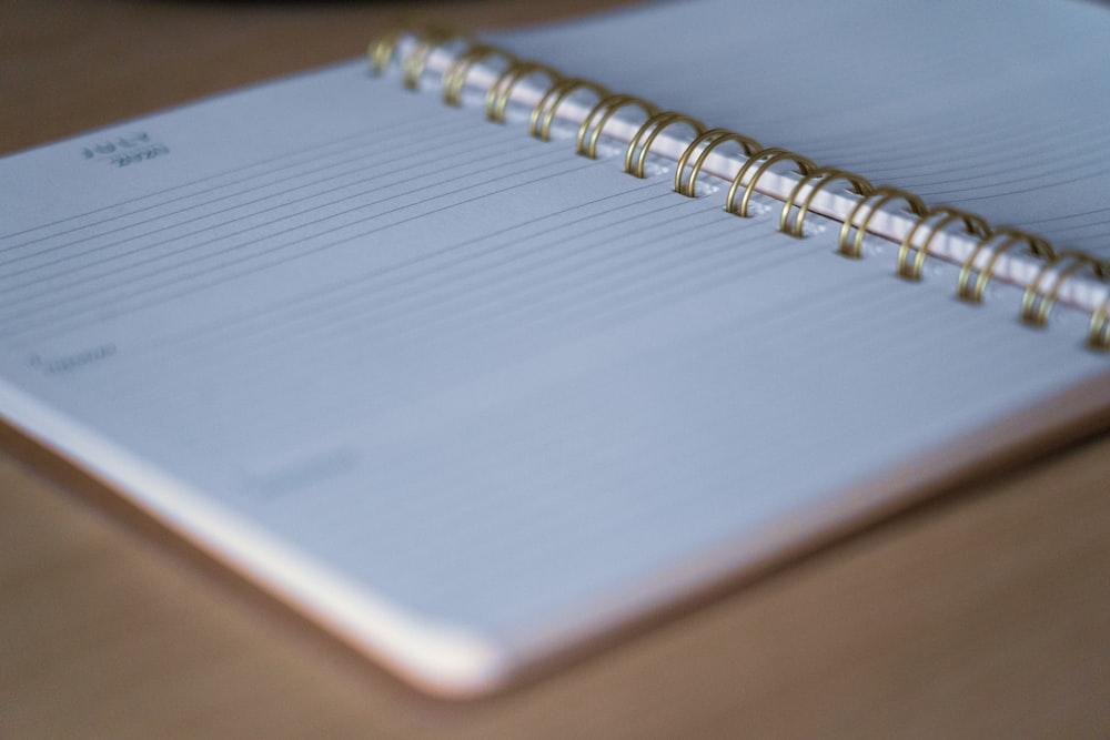 white spiral notebook on brown wooden table