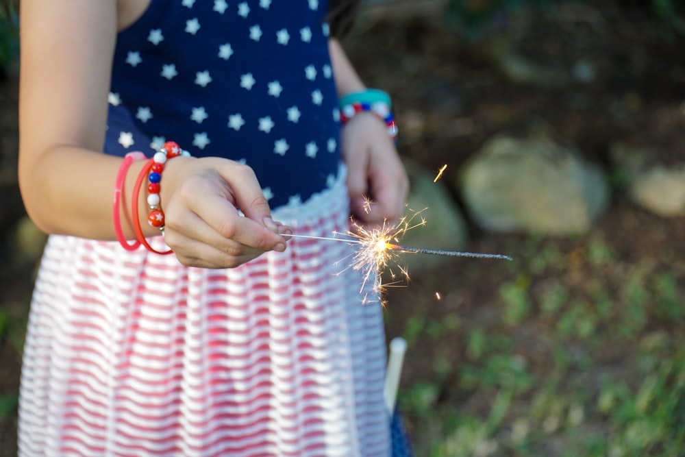 person in blue and white polka dot shirt holding brown and green plant