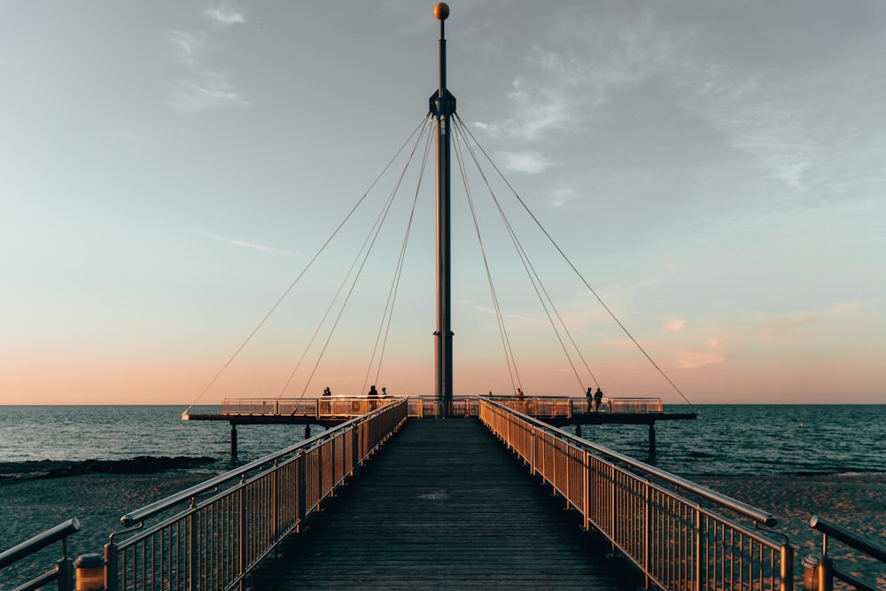 brown wooden dock on sea under white clouds during daytime