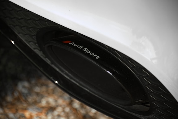 Close-up of colorful VW and Audi centre caps arranged on a sleek black surface.