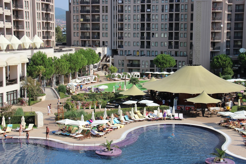 people on swimming pool near high rise buildings during daytime