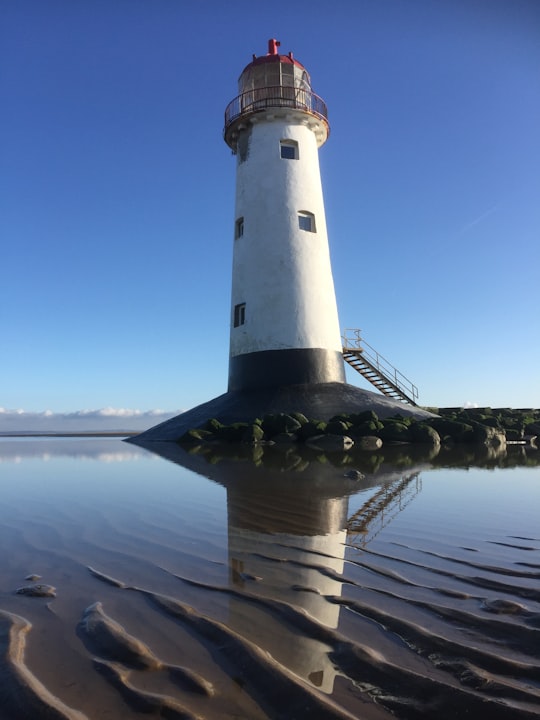 white and black lighthouse near body of water during daytime in Point of Ayr Lighthouse United Kingdom