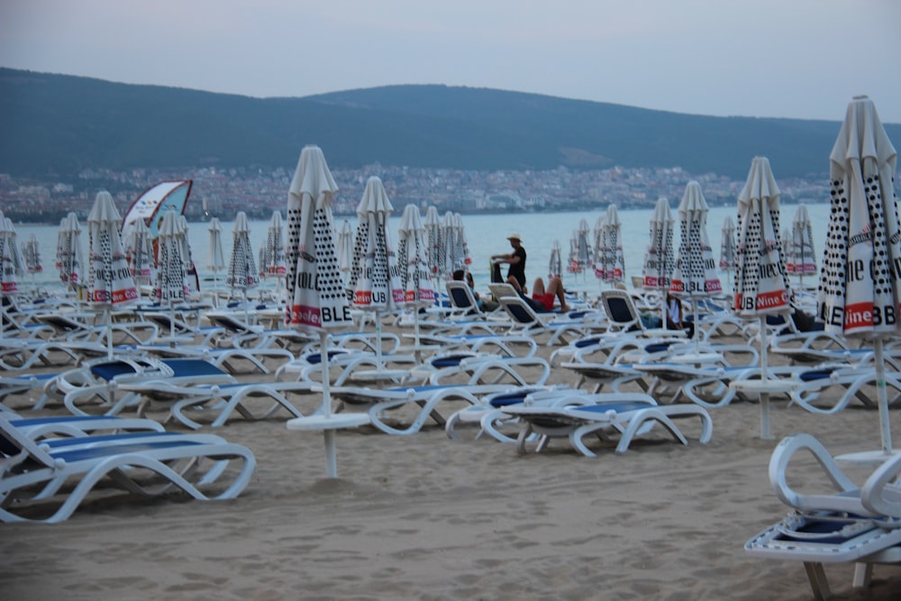 white and blue folding chairs on beach during daytime