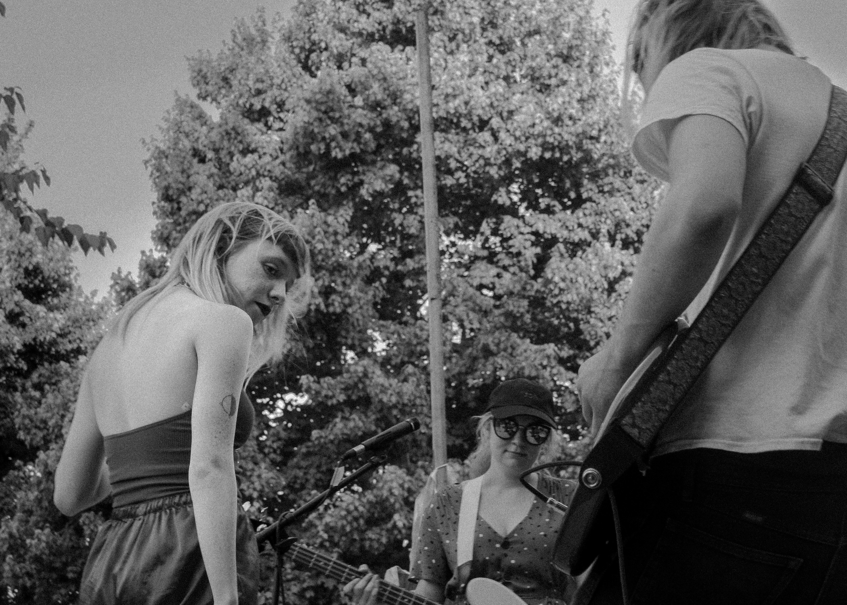 woman in tank top and skirt standing beside man in sunglasses