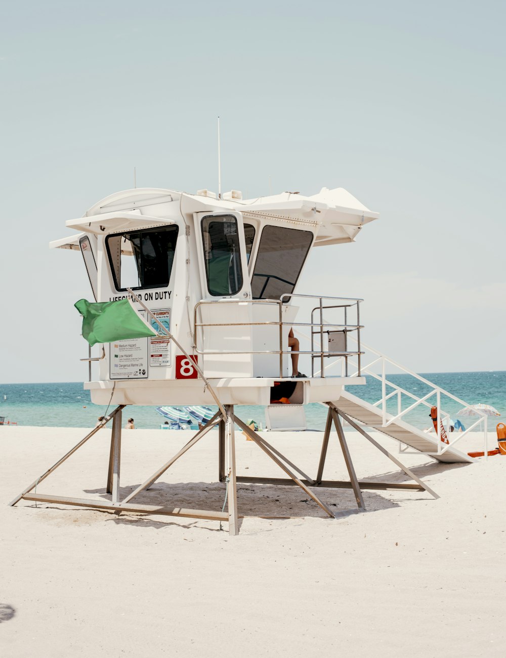 white and green wooden lifeguard house on beach during daytime