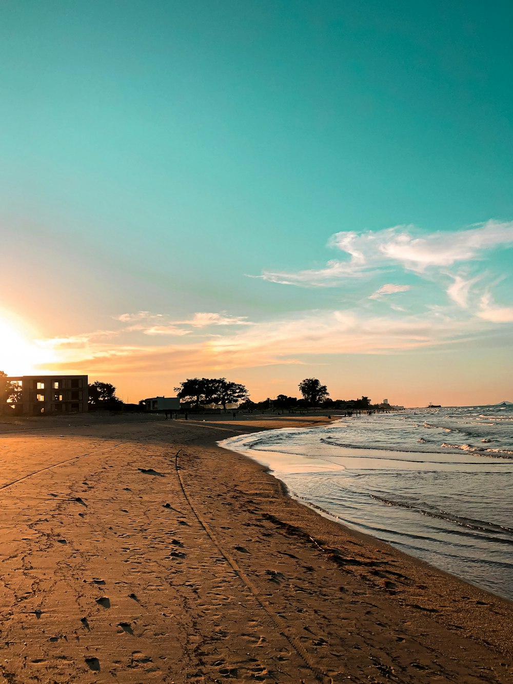 silhouette of building near beach during sunset