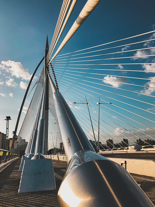 white metal bridge under blue sky during daytime in Putra Bridge Malaysia