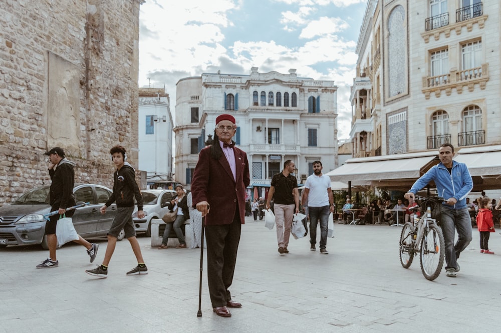 man in red suit walking on sidewalk during daytime