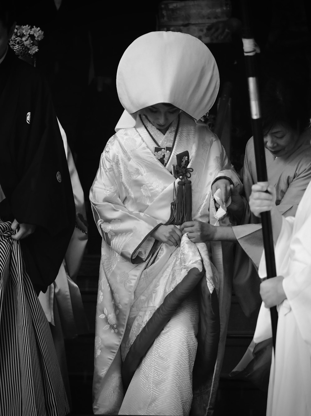 man in white robe holding stick