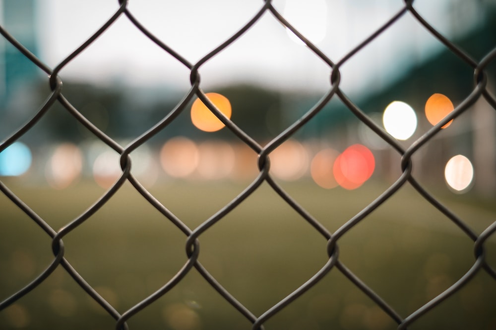 grey metal fence with yellow light