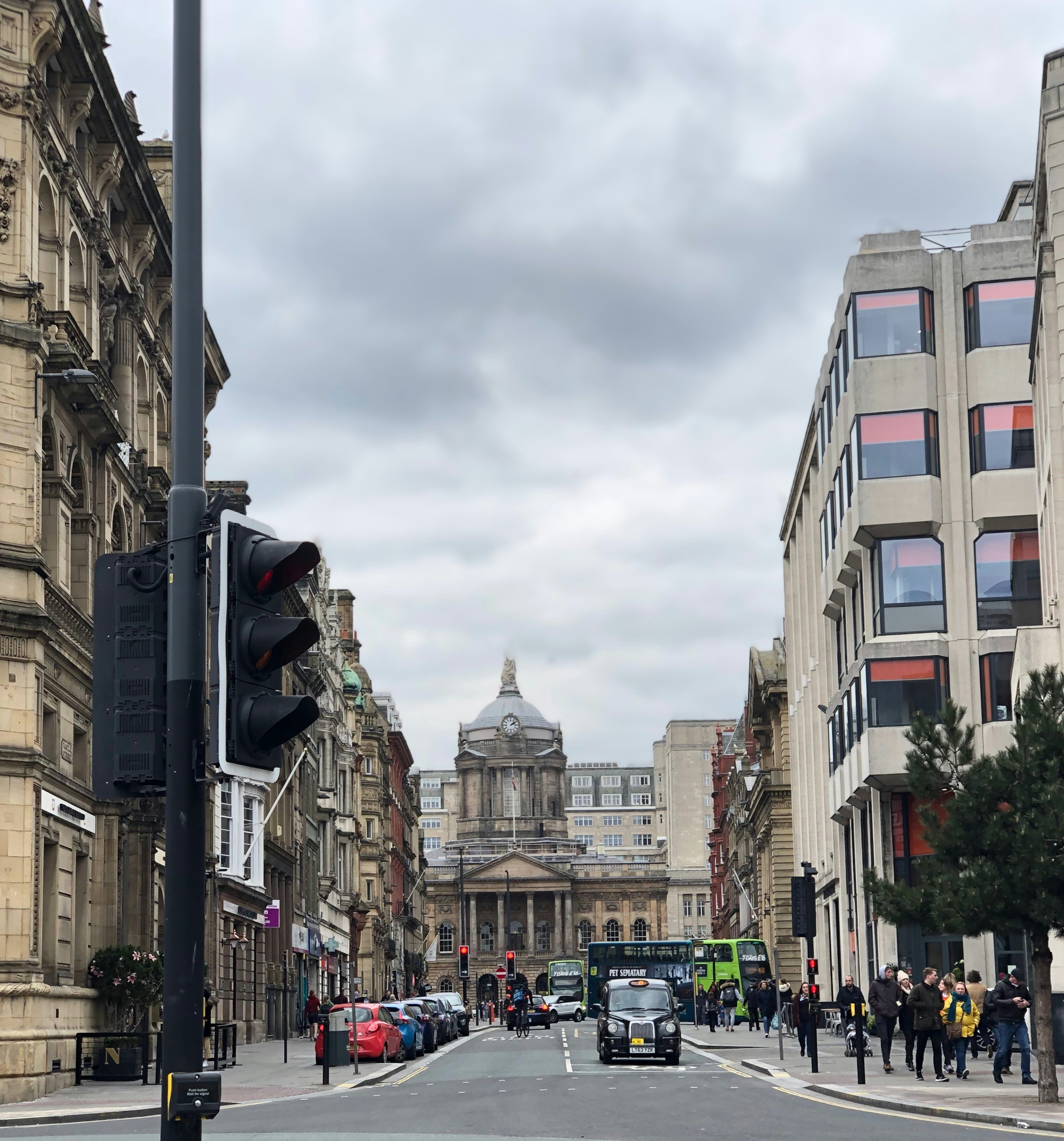 cars on road between high rise buildings during daytime