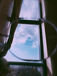 A bright, sunlit living room with sparkling clean windows showcasing a clear blue sky.
