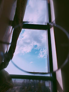 Bright, spotless window reflecting a clear blue sky with a subtle shimmer of sunlight.