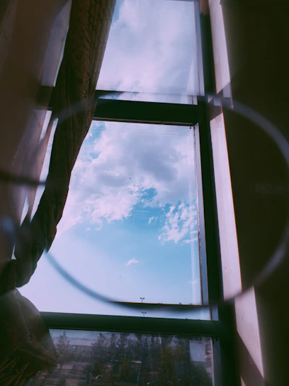 Bright, spotless window reflecting a clear blue sky with a subtle shimmer of sunlight.