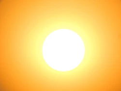 A bright white sun centered against a vibrant orange sky