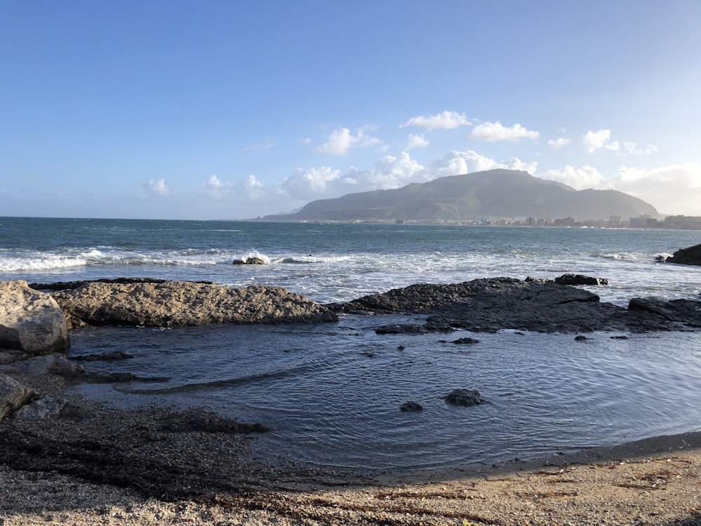 black rocks on sea shore during daytime