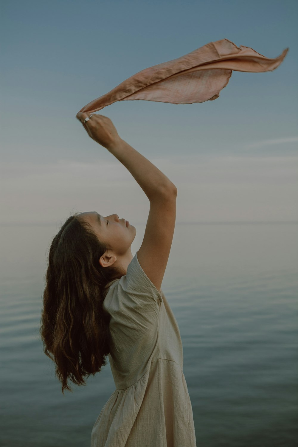 woman in gray shirt raising her hands