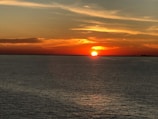 A vibrant sunset over a calm ocean reflecting colors.
