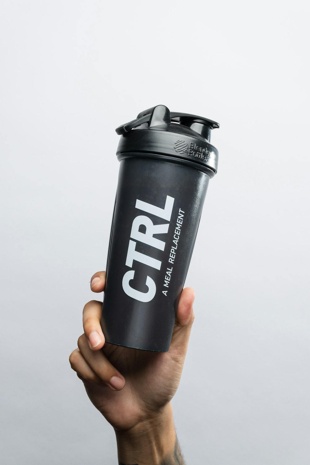 person holding black and white adidas tumbler