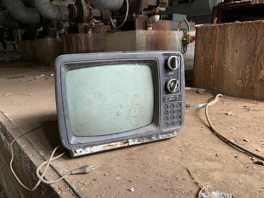 Grauer CRT-Fernseher auf brauner Erde