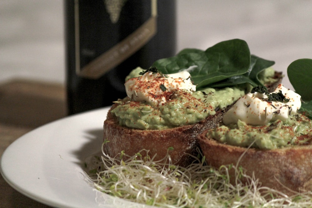 brown bread with green vegetable on white ceramic plate