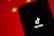 A smartphone displaying the TikTok logo on its screen, set against a background with the colors and patterns resembling the Chinese flag, predominantly red with yellow stars.