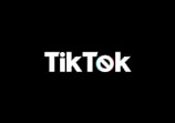 A minimalist logo featuring the word TikTok in a bold, white font centered on a black background. The 'o' in TikTok is stylized with a design resembling a musical note, incorporating subtle blue and red hues.