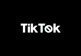 A minimalist logo featuring the word TikTok in a bold, white font centered on a black background. The 'o' in TikTok is stylized with a design resembling a musical note, incorporating subtle blue and red hues.