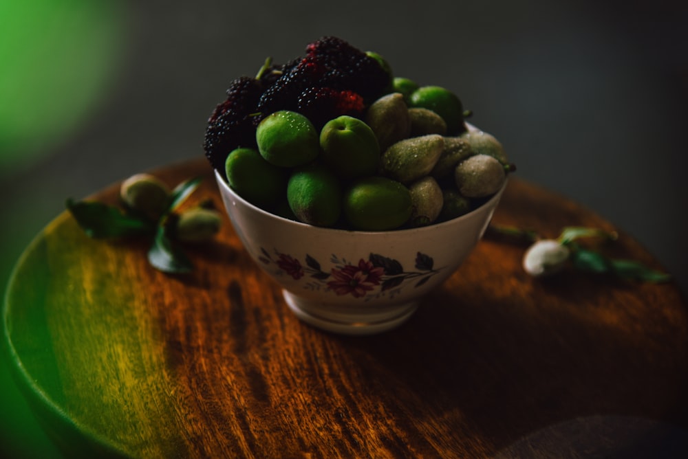 green and purple grapes in white ceramic bowl