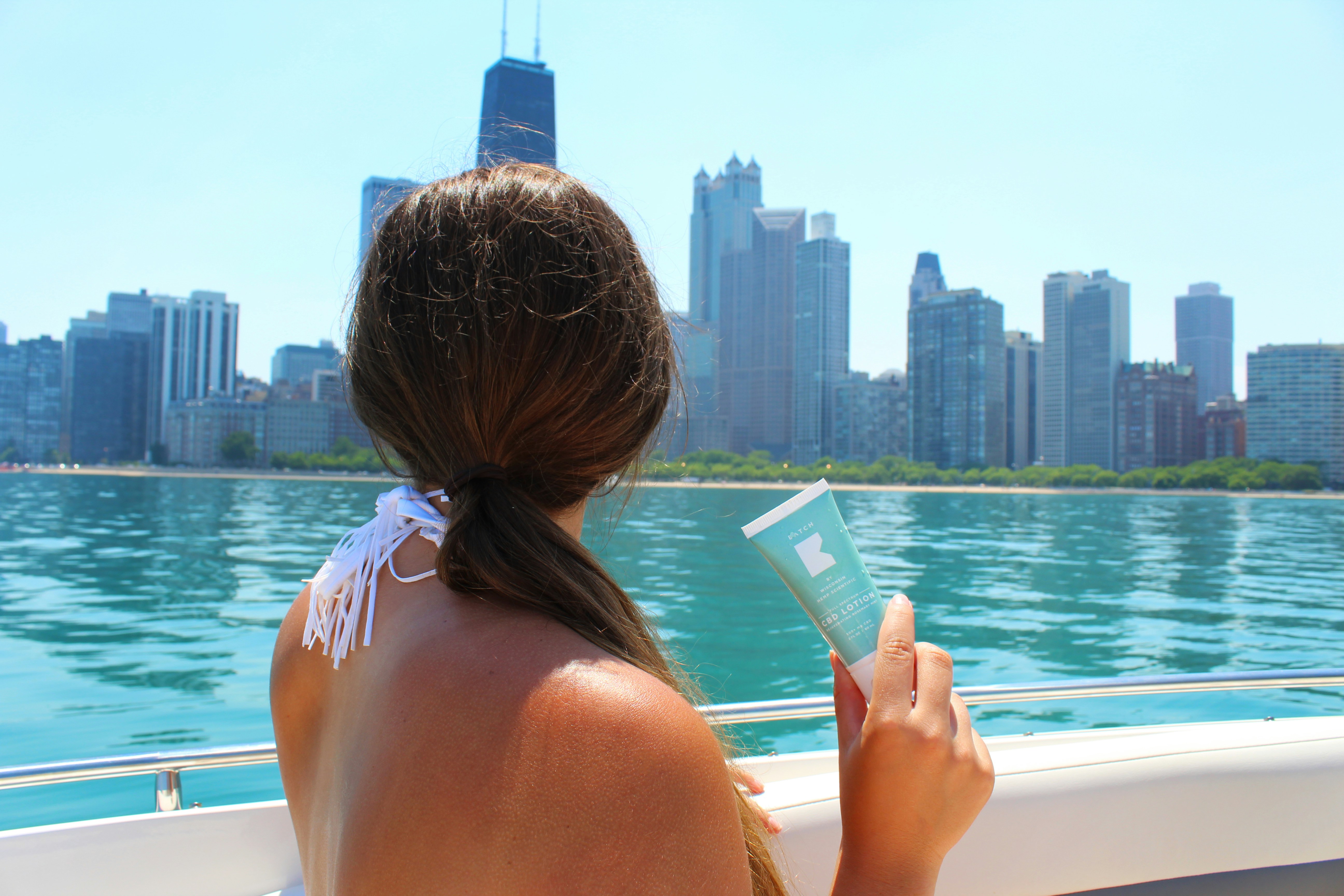 Girl holding BATCH lotion on boat