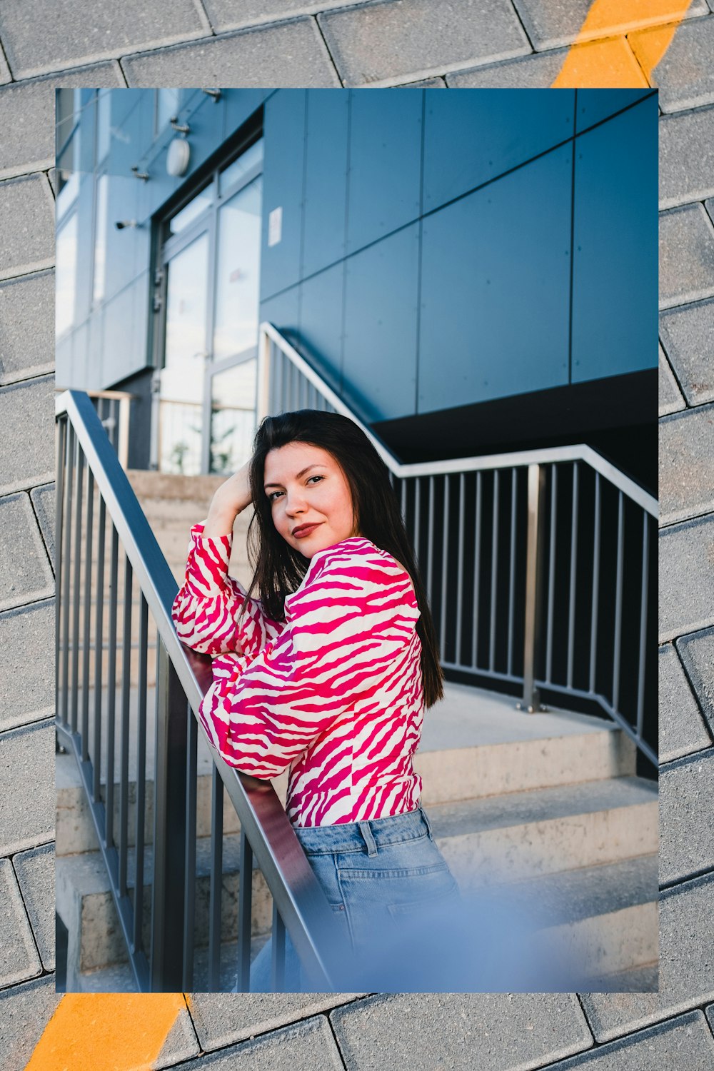 woman in red and white striped long sleeve shirt and blue denim jeans standing on stairs